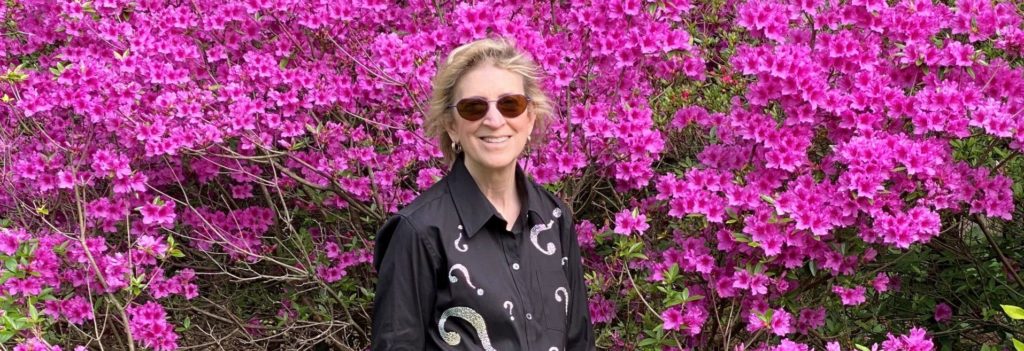 Ann Friedman in front of bright purple flowers