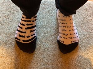 White and black socks with the names of banned books blacked out and uncensored