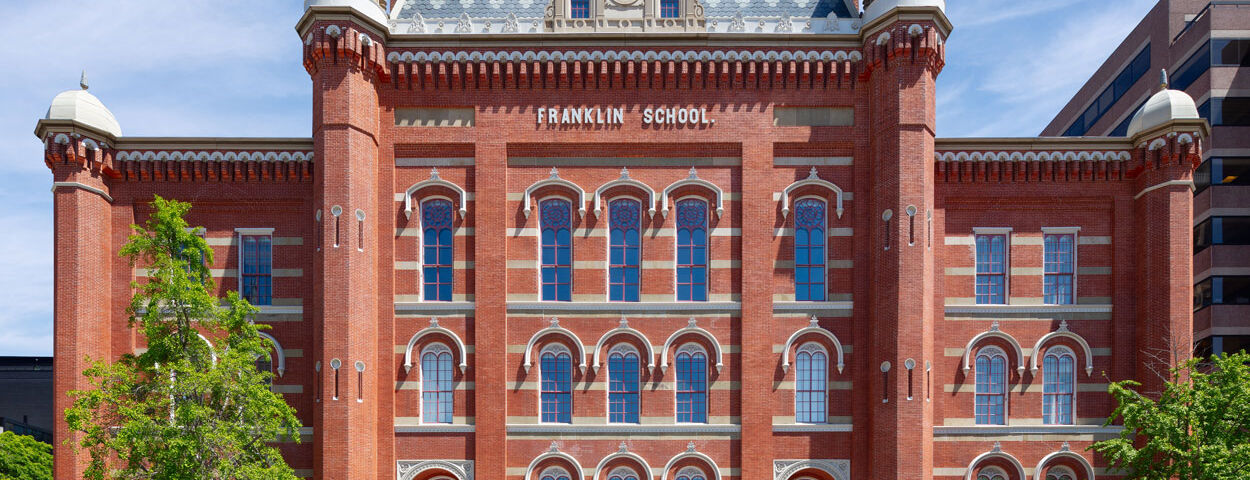 The front of Planet Word, a red brick building with decorative windows, cupolas, and a mansard roof. Planet Word is a LEED Silver Certified museum.