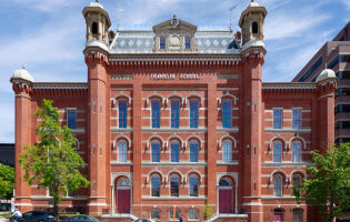 The front of Planet Word, a red brick building with decorative windows, cupolas, and a mansard roof. Planet Word is a LEED Silver Certified museum.